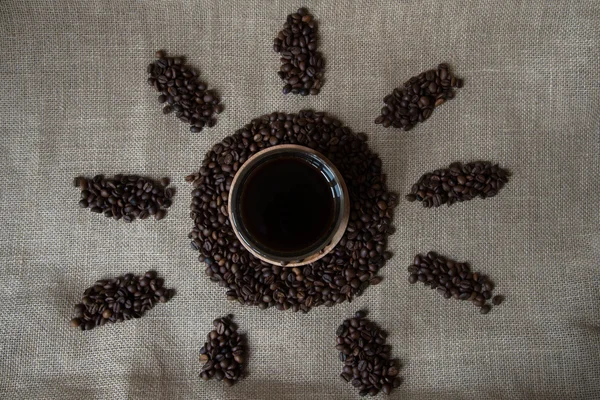 Cup with coffee and beans. On burlap background — Stock Photo, Image