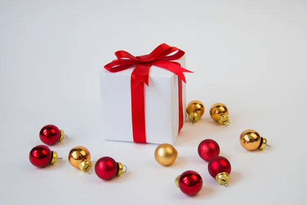 Caixa de presente branco com fita vermelha e bola de Natal — Fotografia de Stock