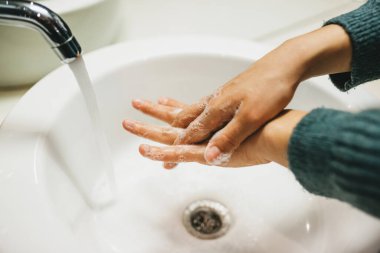 Kız ellerini sabunla yıkıyor. Kişisel temizlik ve temizlik..