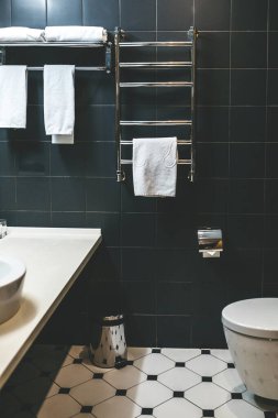 Havlular banyodaki ısıtılmış havlu korkuluklarında asılı..