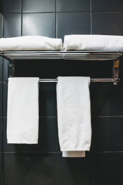 Temiz beyaz havlular banyoda asılı..