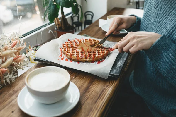 The girl cuts a waffle — Stock Photo, Image