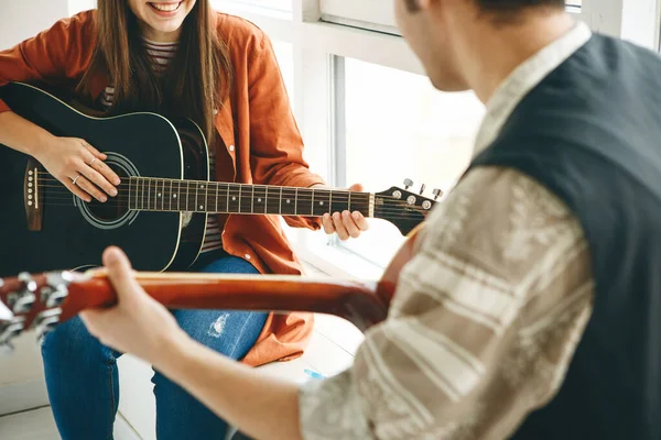 Gitar çalmayı öğreniyorum. Öğretmen öğrenciye gitar çalmanın temel kurallarını açıklar. Bireysel evde eğitim ya da ders dışı eğitim.