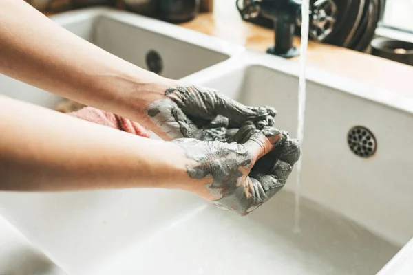 Potter si umyje ruce po vylisování hlíny. — Stock fotografie