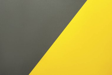 Background of two colors. Yellow and gray paper sheets divided diagonally.