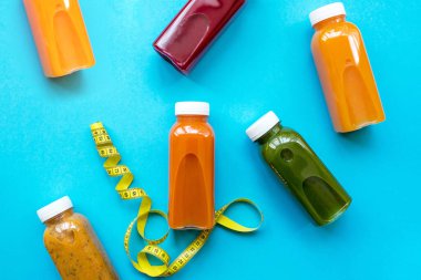 Renkli taze meyve suları ya da mavi arka planda meyve ve sebze kokteylleri..