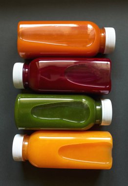 Gri arka planda meyve ve sebzelerin taze meyve suları ya da meyve suları. 