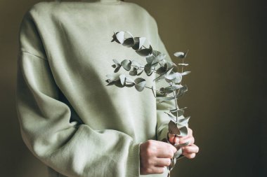 Bir kadın elinde okaliptüs tutuyordu..