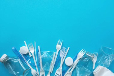 Mavi arka planda beyaz plastik çöp. Plastik geri dönüşüm ve ekoloji kavramı. 