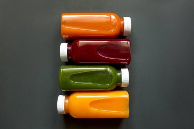 Gri arka planda meyve ve sebzelerin taze meyve suları ya da meyve suları. Düz Ley, üst görünüm.