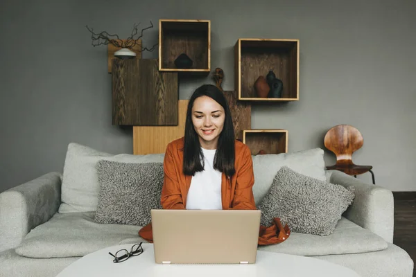 Una hermosa joven europea usando un ordenador portátil para el trabajo remoto desde casa. — Foto de Stock