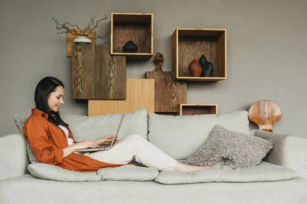 Una hermosa joven europea usando un ordenador portátil para el trabajo remoto desde casa. — Foto de Stock