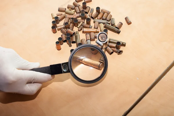 Deskundige door een vergrootglas op zoek naar een kogel — Stockfoto