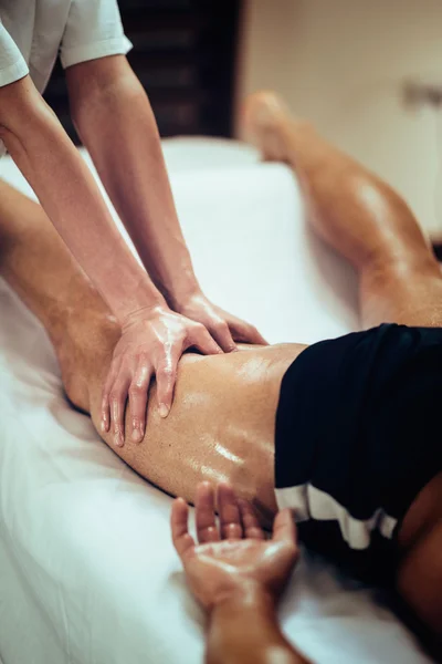 Vrouwelijke fysieke therapyst masseren been Stockfoto