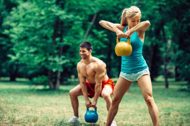 Couple working out with kettle bells clipart