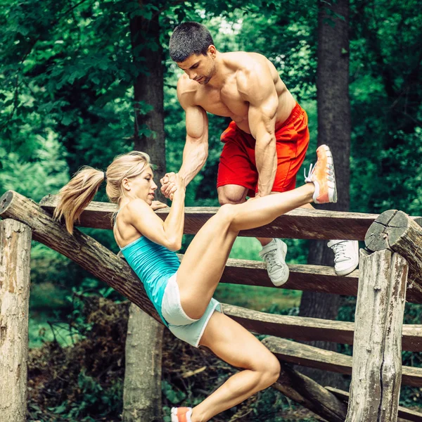 Fitness trail couple crossing obstacle — Stock Photo, Image