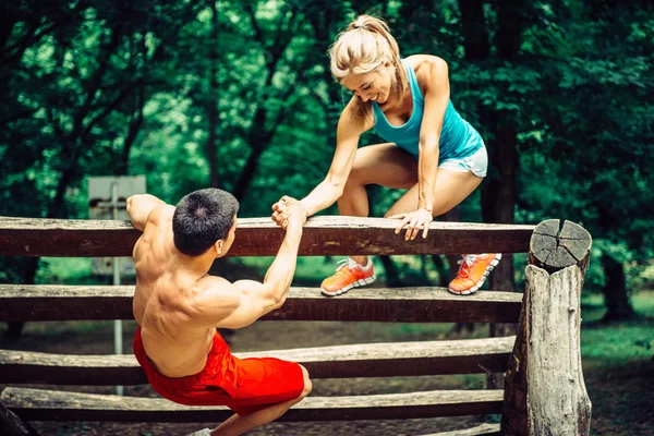 Fitness trail couple crossing obstacle — Stock Photo, Image