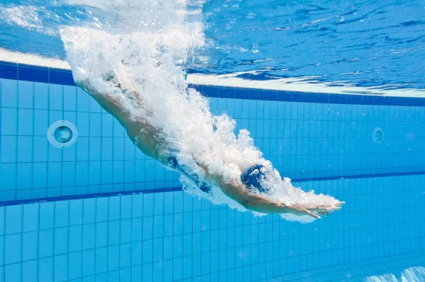 Vrouw duikt in het zwembad — Stockfoto