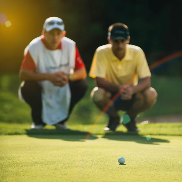 Гравець у гольф та caddy читання зелений — стокове фото