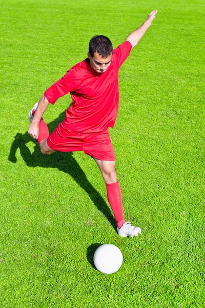 Un footballeur donne un coup de pied au ballon — Photo