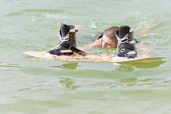 Wakeboarder swimming behind his board — Stock Photo, Image