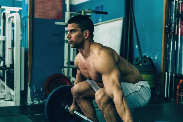 Uomo sollevamento pesi nel centro sportivo — Foto Stock