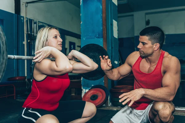 Treinamento de levantamento de peso feminino com treinador — Fotografia de Stock