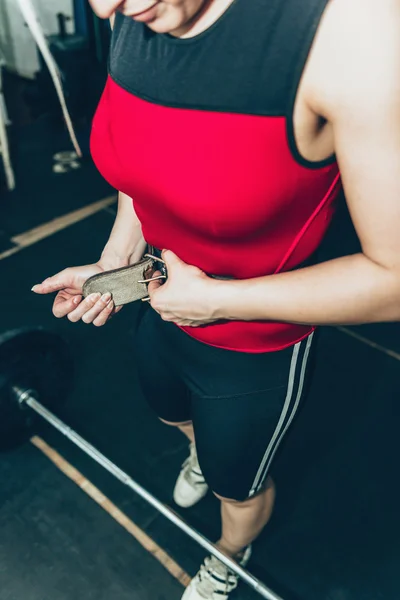 Female tightens belt at weightlifting training — Stock Photo, Image