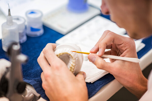 dentist working with tooth dentures 