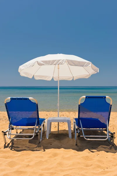 Praia de areia com cadeiras de sol — Fotografia de Stock