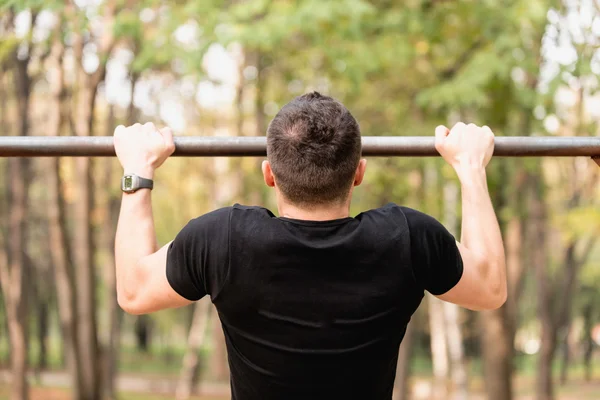 Homem fazendo pull ups — Fotografia de Stock