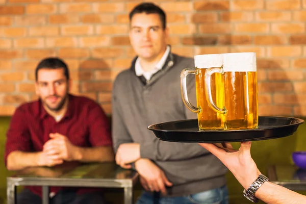 Kellner bringt Bier für Freunde — Stockfoto