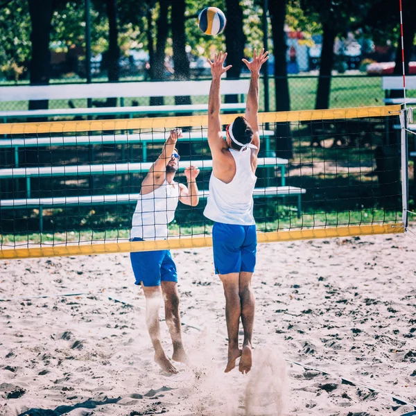 Игроки в пляжный волейбол в сети — стоковое фото