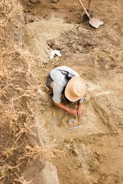 Arqueólogo recuperando restos humanos de la tumba antigua — Foto de Stock