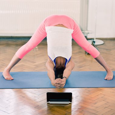 Evde yoga yapan bir kadın.