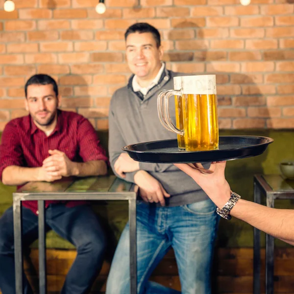 Cameriere portando birra per gli amici — Foto Stock