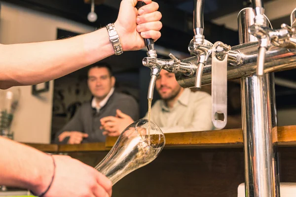 Bartender pouring beer from tap — Stock Photo, Image