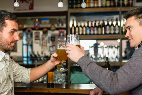 Přátelé pijící pivo v baru — Stock fotografie