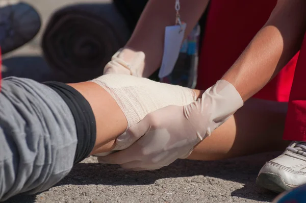 Paramedic treating knee injury — Stock Photo, Image