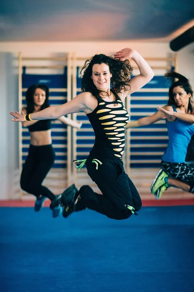 Mulheres pulando na aula de fitness de Zumba — Fotografia de Stock