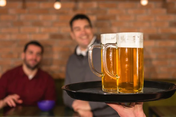 Camarero trayendo cerveza para amigos — Foto de Stock