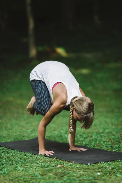 Woman doing crow position — Stock Photo, Image