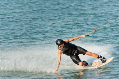 Wakeboarder enjoying ride on lake clipart