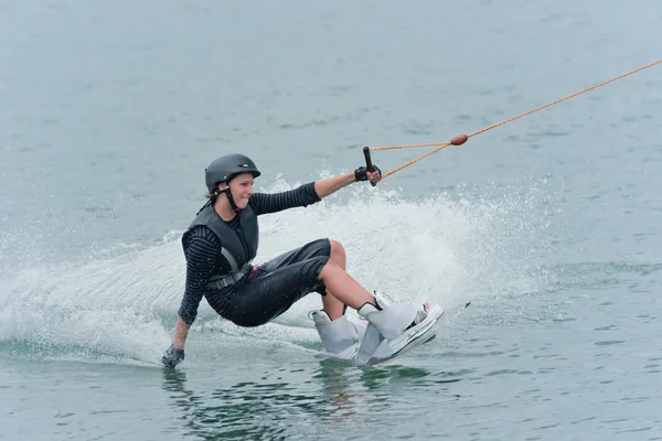 Wakeboarder touching water with hand — Stock Photo, Image