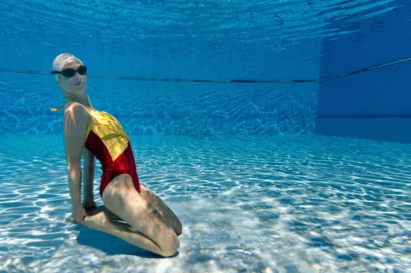 Gesynchroniseerde zwemmer poseren onderwater — Stockfoto