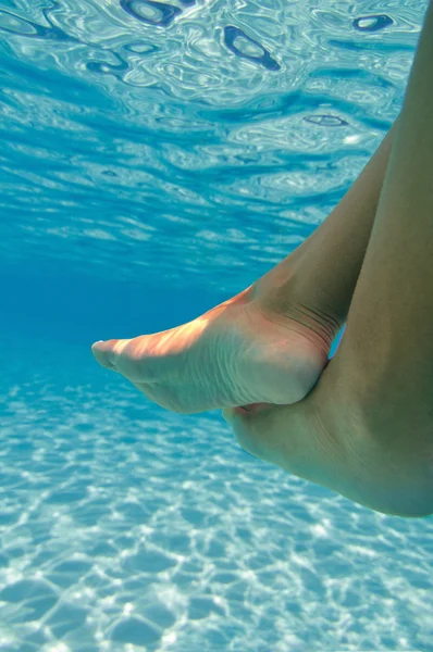 Pies femeninos en lado de la piscina — Foto de Stock