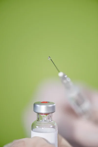 Seringa com gota sobre o frasco para injetáveis da vacina — Fotografia de Stock