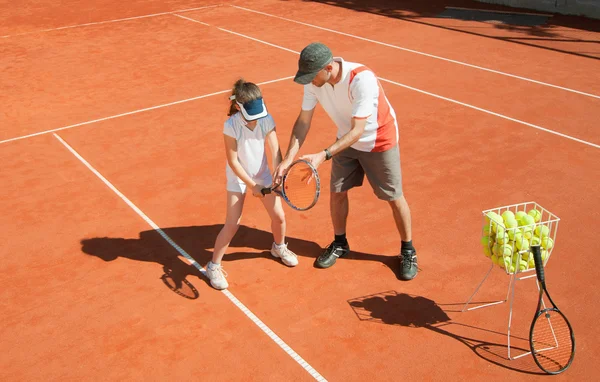 Treinador com menina no campo de ténis — Fotografia de Stock