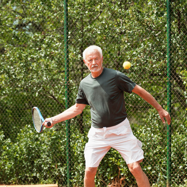Senior man playing tennis