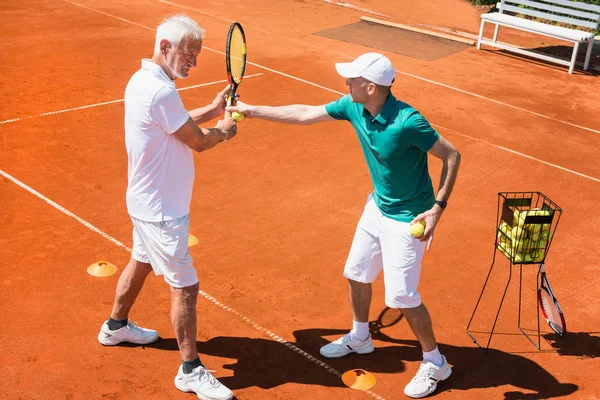 Äldre man har tennis lektion — Stockfoto